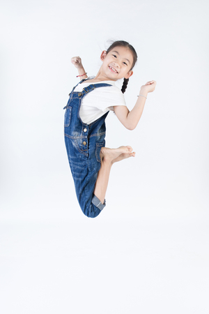 Asian cute child is jumping on gray backgroundの写真素材