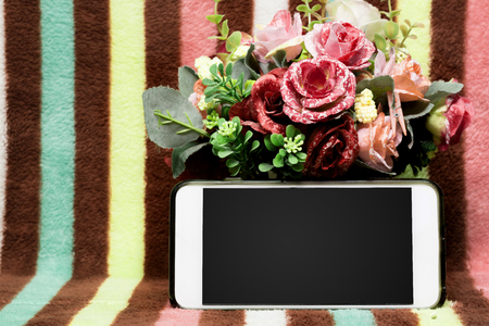 phone with copy space and bouquet of flowers on colorfull backgroundの写真素材