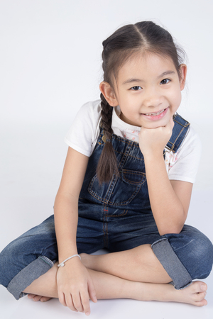 Asian cute girl in jump suit with smile face, on gray backgroundの写真素材