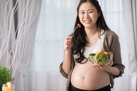 Asian pregnant woman on kitchen with healthy vegetable .の写真素材