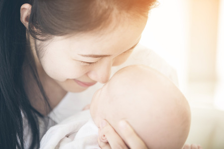 Asian mother and baby son plays, lovely moment with sun light in the morningの写真素材