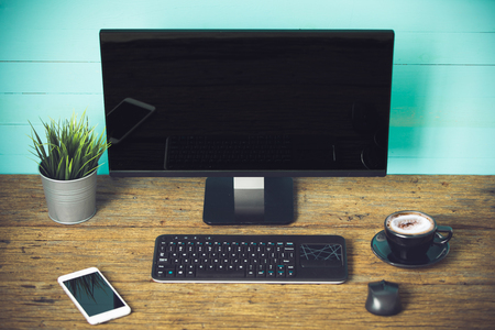 Mix of office supplies and gadgets on a wooden table .の写真素材