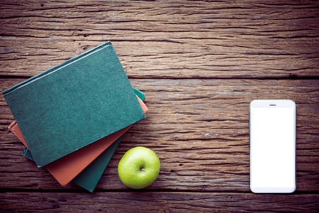 Green apple , books with cell phone on wooden background.の写真素材