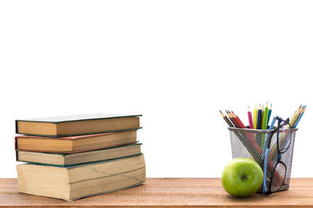 Mix of office supplies and green apple on a wooden table with white background.の写真素材