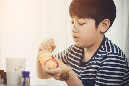 Portrait of a cute little boy messily playing with paints.の写真素材