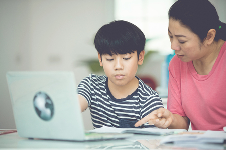 Asian boy with mother teaching and learning your homework at home 