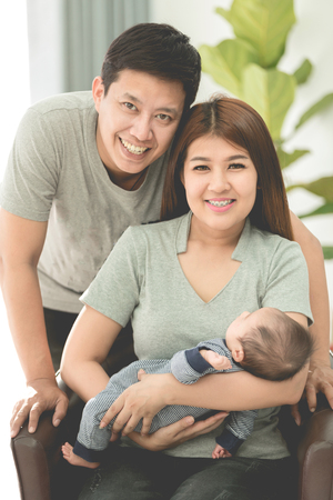 Proud Asian Mother And Father At Home With Baby.の写真素材