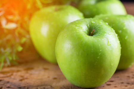 Green apple with water drop on wood tableの写真素材