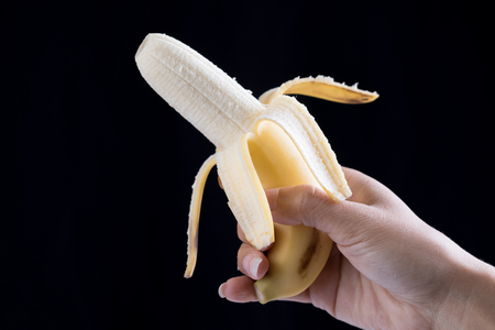 Banana in hand on black backgroundの写真素材