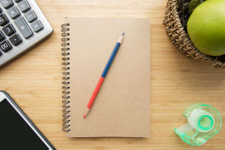 Mix of office supplies and gadgets on a wooden desk background. View from above.の写真素材