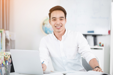 Young Asian man university student working with laptop computer and notebook , self learning and college lifestyle conceptsの写真素材