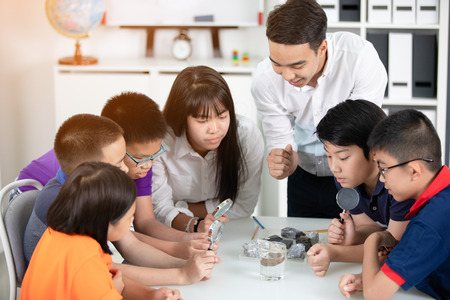 Asian teacher expanding to student in geology class with different of rock .の写真素材