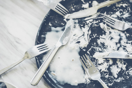 Black dish with fork  knife and spoon empty after eat.の写真素材
