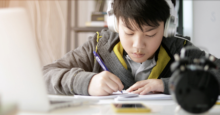 Cute asian teen boy doing your homework at home.