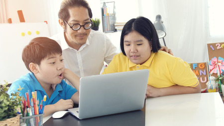 Tutor room children in class learning on laptop computer with teacher. Asian child learning with...