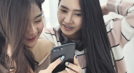 Beautiful asian girl using mobile cellphone with smile face.の写真素材