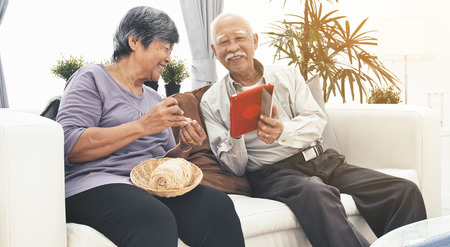 Asian Senior couple e-shopping with digital tablet, Senior couple online shopping with smile face.の写真素材
