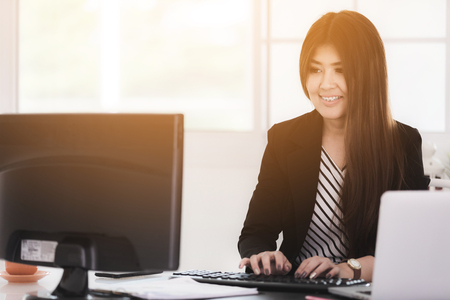 Portrait of a cheerful businesswoman sitting at the table in office .の写真素材