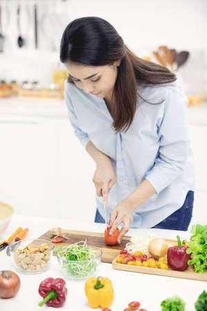 Young asian mother making food in the kitchen with smile face.の写真素材