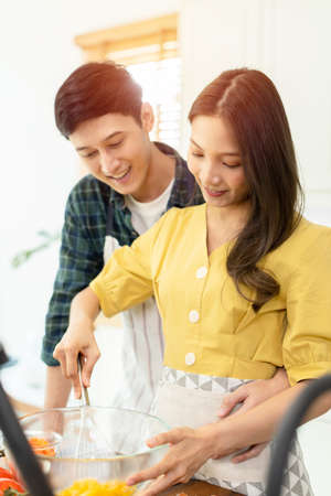 A couple breaks an egg to make a morning omelet at home. Romantic time For a newly married couple.の写真素材
