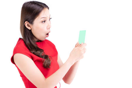 Portrait beautiful woman in a red dress , Frightened expression I was looking at something on my hand. On a white backgroundの写真素材