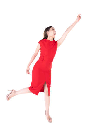 A beautiful woman in a red dress Showing a happy expression On a white background, A cute woman pretending to pick up things.の写真素材
