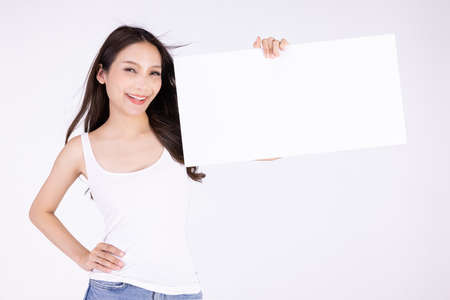 Asian cute woman show with white board isolated on gray backgroundの写真素材