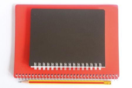 Black and red notebook with pencil on white color backgroundの写真素材