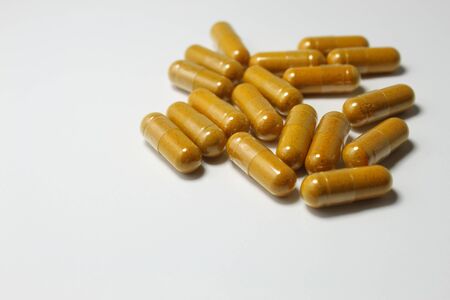 Yellow pills (capsules) isolated on white backgroundの写真素材