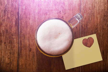 Glass of Beer on the Wooden Table at Bar with Blank Paper Note and Heart Shape