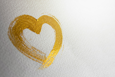 Gold heart brush stroke on white drawing paper, Selective focusの写真素材