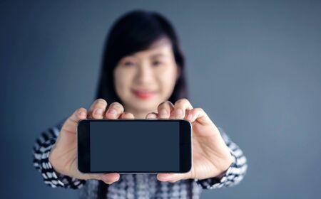 Smart Phone Mockup image with Long Black Hair Asian Female Model holding and showing a mobile with...