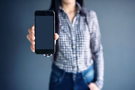 Smart Phone Mockup image with Long Black Hair Female Model holding and showing a mobile with blank...