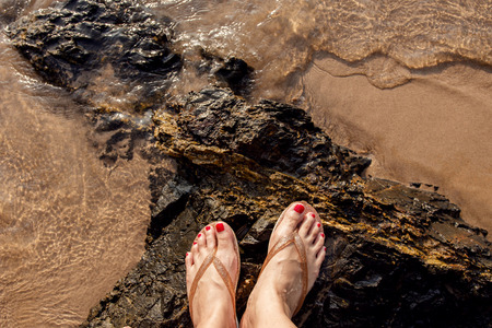 Female stand on island rock in summer beach, top viewの写真素材