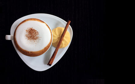 Hot Cappuccino with cookie and cinnamon isolated on black background, top viewの写真素材