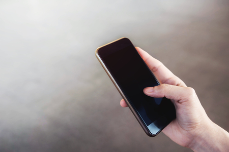 Female hand holding Smart Phone with plenty for copy, top viewの写真素材