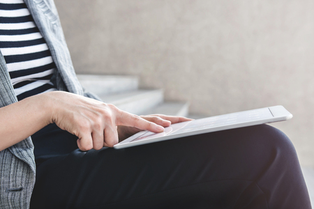 Hand of Business working woman sit and using digital tablet at outdoor stair, Close up shotの写真素材