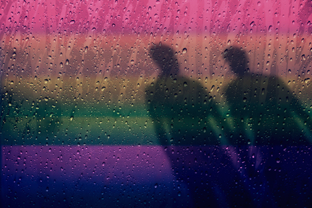 Blurred Shadow Shape of male lover on Rainbow light Background, Rain drop as foreground and in focus, Gay or Homosexual Conceptの写真素材