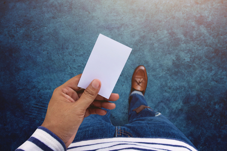 Blank business card on hand for mock up, Top view, present by casual urban guyの写真素材