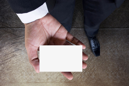Business card mockup on Businessman hand, Top view, Clipping path included, Blank space for logo identity or text copy, Cement concrete floor as backgroundの写真素材