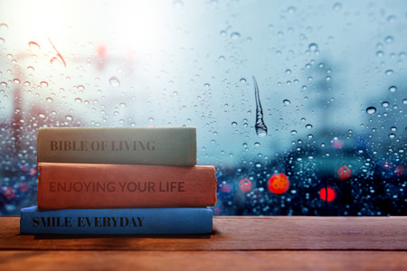 Life and Living Positive concept, Reading Book in Rainy Day in House, Blurred light in city as outside viewの写真素材