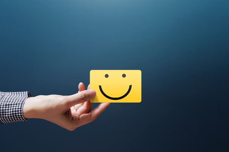 Customer Experience Concept, Happy Client Woman show a Feedback with Happy Smiley Face Cardの写真素材