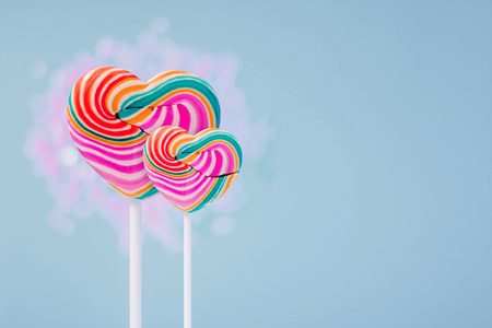 Love and Valentines Day Concept. Couple of Heart Sweet Lollipop Candy present over pastel blue backgroundの写真素材