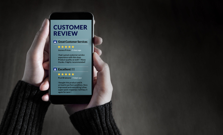 Customer Experience and Online Review Concept. Female holding SmartPhone to Reading Customer Review before Buying Productsの写真素材
