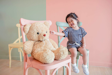 Soft Focus of a Two Years Old Child Sitting with her Teddy Bear. Happy and Lovely Kidsの写真素材
