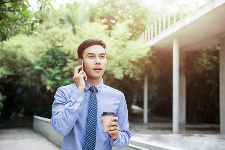 Young Motivation Businessman Talk via Smartphone while walk outdoor, Lifestyle of Modern Maleの写真素材