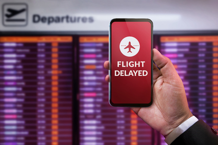 Modern Technology in Travel Concept. Flight Delayed on Smartphone Screen. Businessman using Mobile...