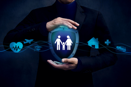 Concept For Insurance Company to Safe and Support thire Customer, Family icon inside a Shield Guard. Protected by Hands of Businessmanの写真素材