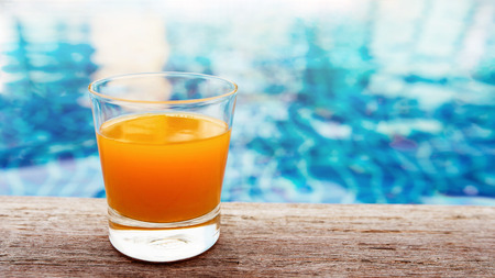 Summer Drink at the Swimming Pool. Glass of Orange Juice on the Poolside. Relaxation on Vacation or...