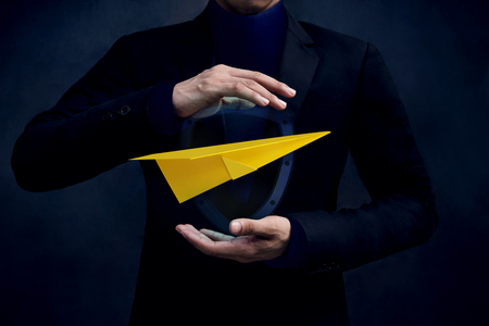 Travel Insurance Concept. Airlines industry Safe and Supporting Customer, Paper Airplane floating and Protected by Careful Gesture Hands of Businessmanの写真素材